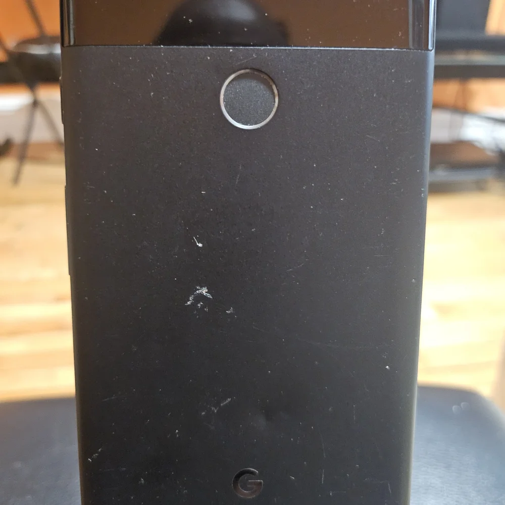 Sleek Black Smartphone with Coastal Display